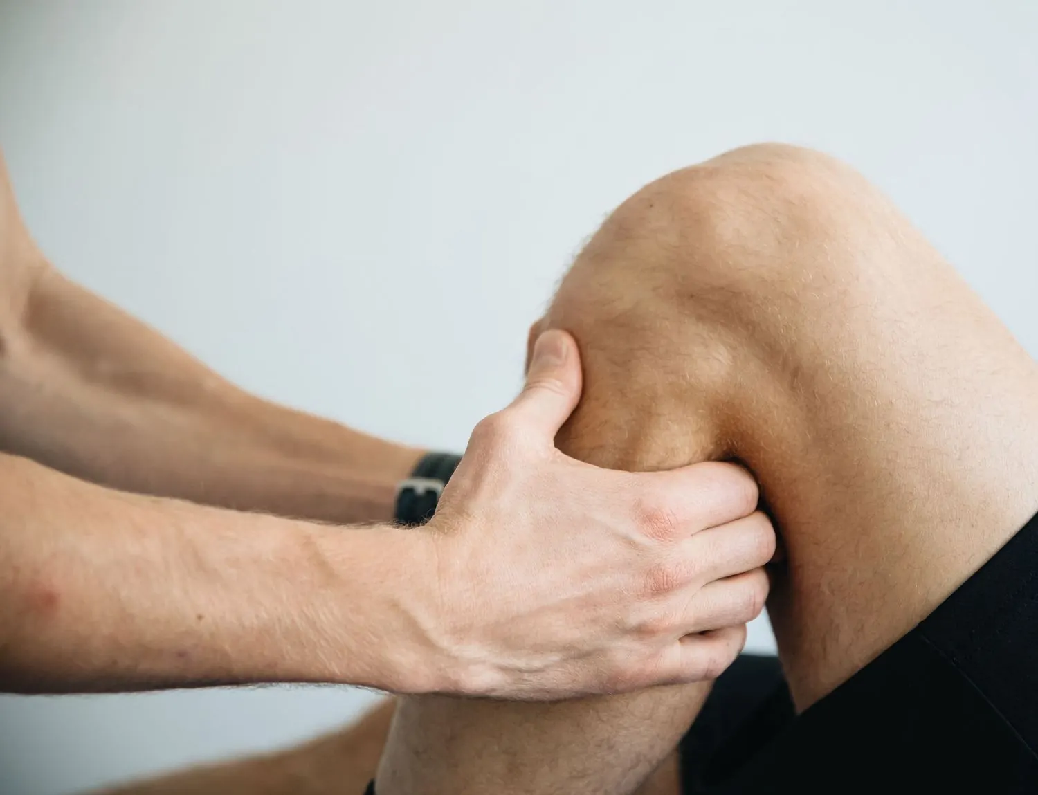 Kinésithérapeute qui traite le genou d'un patient